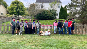 L'équipe wenglor USA se tient en tenue de cow-boy devant une clôture western lors d'un BBQ d'été dans le style Far West.